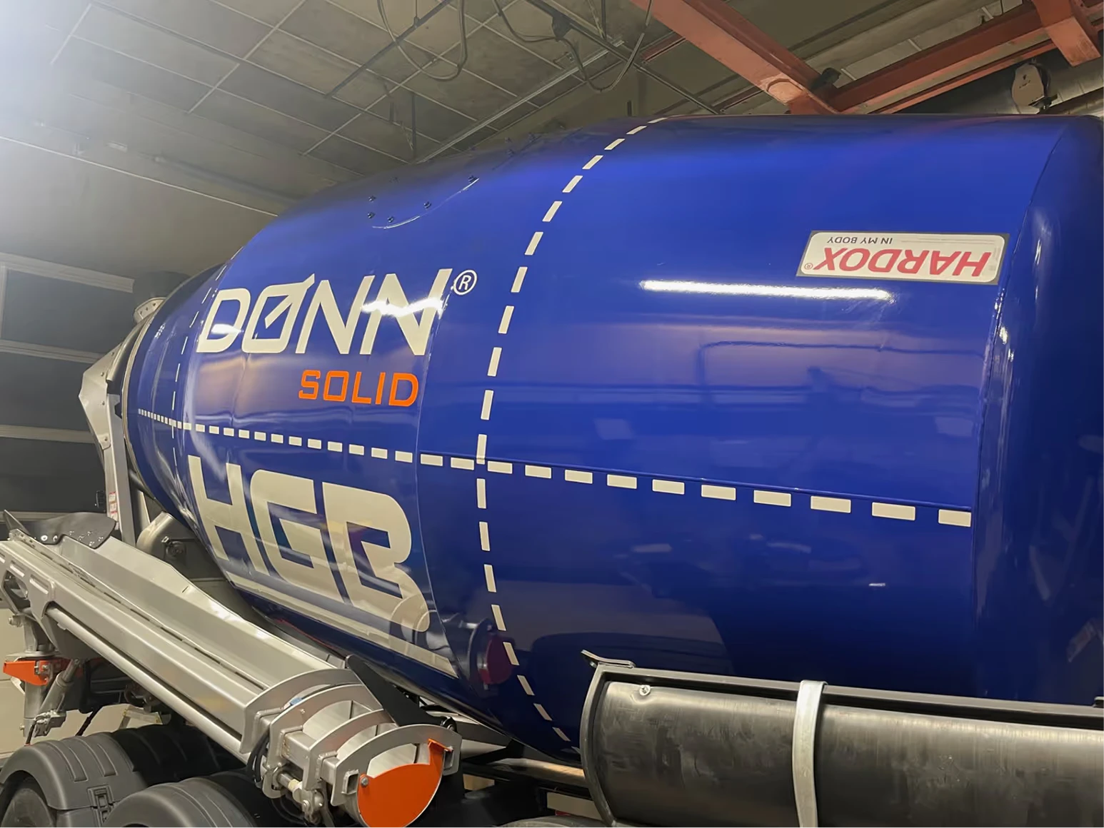 Nærbilde av logoen på den blå betongbilen til HGB Veiservice
