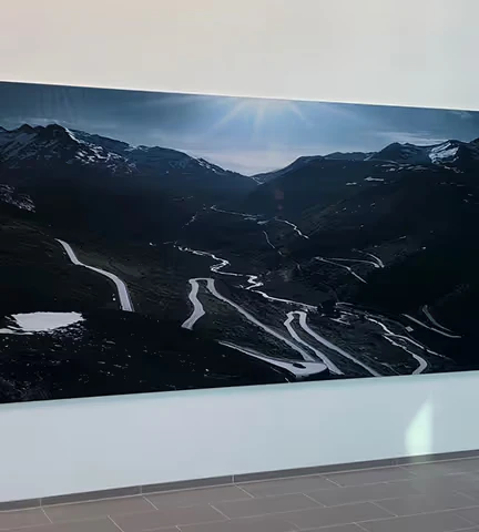 Stort veggbilde med fjellandskap og svingete vei.